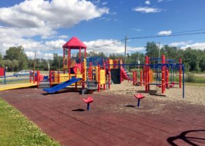 red yellow and blue playground on woodchip surfacing