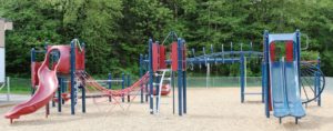 red silver and blue playground on woodchip surfacing