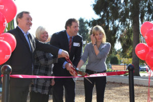people clipping grand opening ribbon at playground