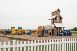 custom playground tower in brown and yellow on woodchip surfacing
