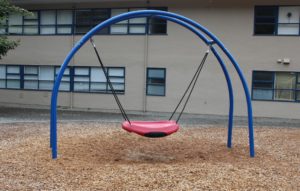 blue and red playground on woodchip surfacing