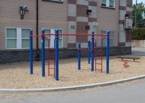 blue and red playground on woodchip surfacing