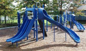 blue and green playground on woodchip surfacing
