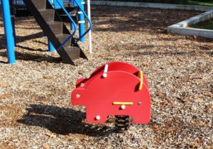 blue and green playground on woodchip surfacing