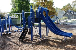 blue and green playground on woodchip surfacing