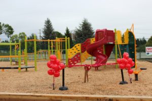 red yellow and green playground on woodchip surfacing