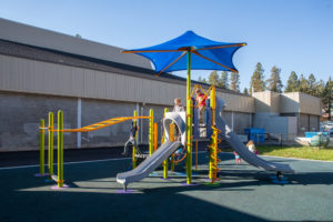 blue and green playground on woodchip surfacing