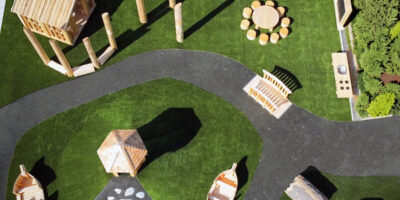 a collection of wood play elements on a site with artificial turf