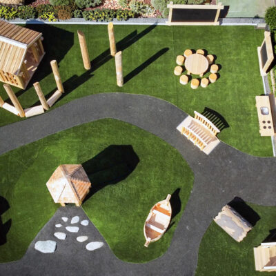 a collection of wood play elements on a site with artificial turf