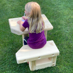 little girl sitting at wooden desk