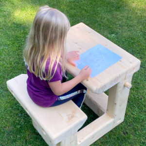 little girl sitting in wooden desk