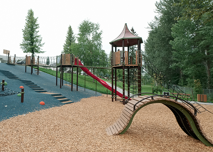 playground on a hillside with climbing nets and slide