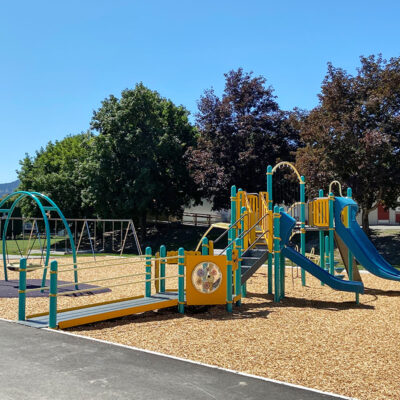 blue and yellow accessible playground on wood surfacing