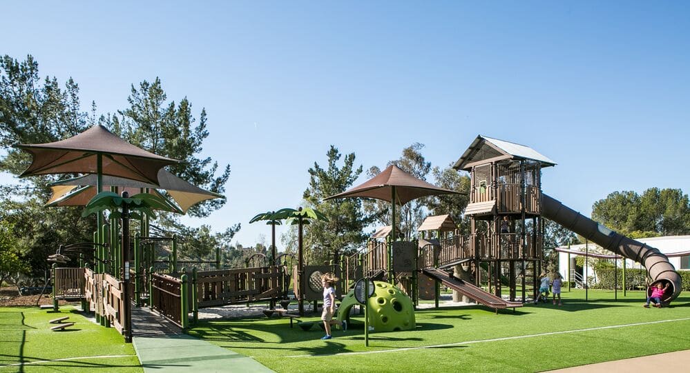 Inclusive Playground Design featuring a natural look and artificial grass surfacing.