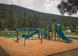 blue and green playground on woodchip surfacing