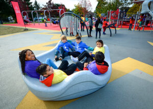 Kids in an accessible spinner on a playground