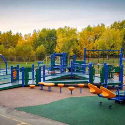 Blue and orange playground and spinner on PIP rubber surfacing