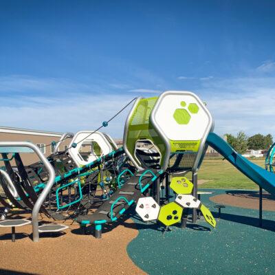 Futuristic blue, silver, and green playground on PIP rubber surfacing