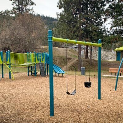 Green and blue playground and swings on wood fibre surfacing