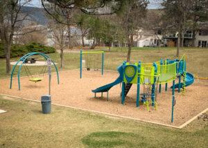 Green and blue playground and swings on wood fibre surfacing