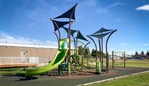 Photo of brown and green playground and swings on PIP rubber surfacing