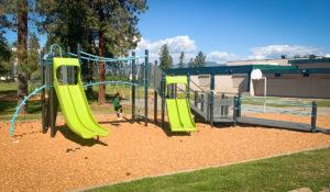 Black, green, and blue playground on wood fibre surfacing