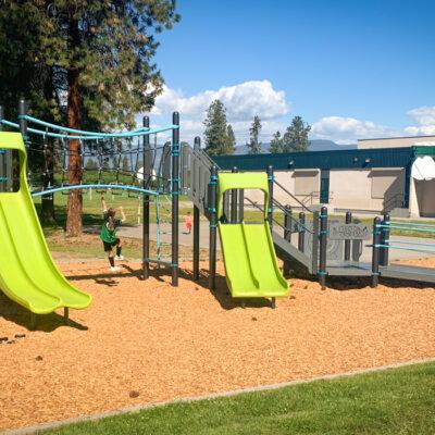 Black, green, and blue playground on wood fibre surfacing