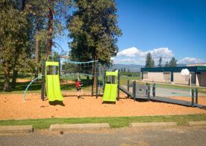 Black, green, and blue playground on wood fibre surfacing