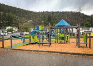 Frey, blue, and green playground on wood fibre with wheelchair ramp