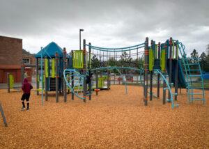 Grey, blue, and green playground on wood fibre