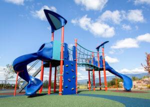blue and red playground with hill slides in the back
