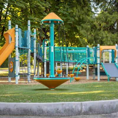 yellow and blue playground on woodchip surfacing