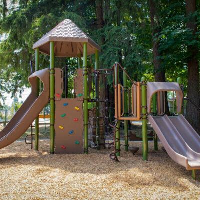 green and brown playground on woodchip surfacing