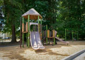 green and brown playground on woodchip surfacing