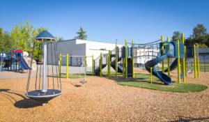 green and blue playground on woodchip surfacing