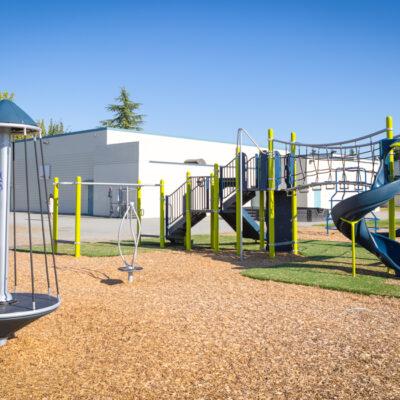 green, blue and silver playground on engineered wood fibre (EWF) & artificial grass surfacing