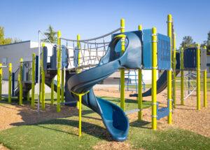 green and blue playground on woodchip surfacing