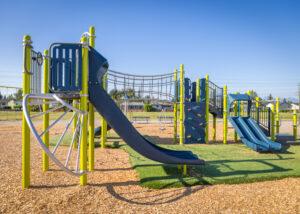 green and blue playground on woodchip surfacing
