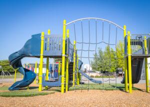 green and blue playground on woodchip surfacing