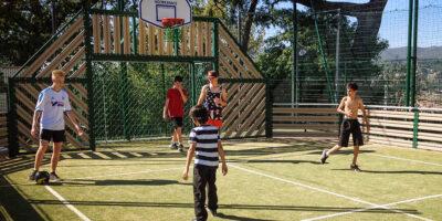 Kids playing soccer on a grassy sports courts