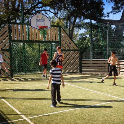 Kids playing soccer on a grassy sports courts