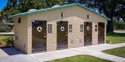 washroom building with stone lower walls, barnwood upper walls with ribbed metal roof