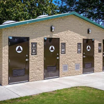 washroom building with stone lower walls, barnwood upper walls with ribbed metal roof