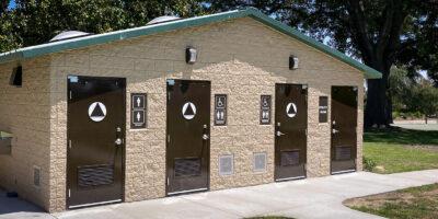 washroom building with stone lower walls, barnwood upper walls with ribbed metal roof