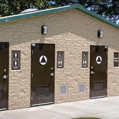 washroom building with stone lower walls, barnwood upper walls with ribbed metal roof