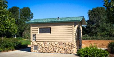 washroom bulding with barnwood siding and rocks