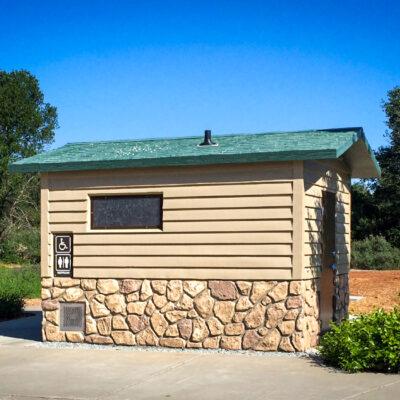 washroom bulding with barnwood siding and rocks