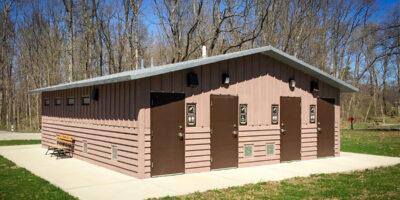 shower building with Board and batt upper walls, horizontal lap lower walls with cedar shake roof