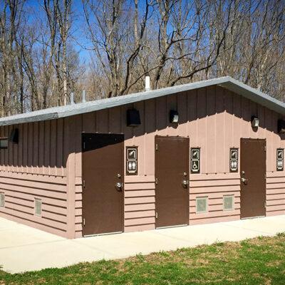 shower building with Board and batt upper walls, horizontal lap lower walls with cedar shake roof