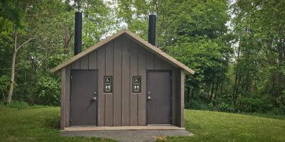 washroom building with Board and batt walls with cedar shake roof